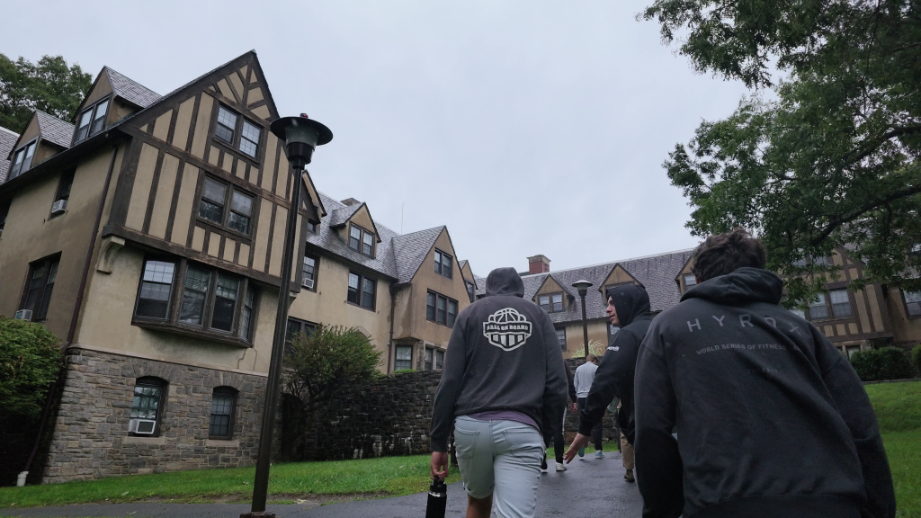 Visitors walk past a row of boarding school dormitories