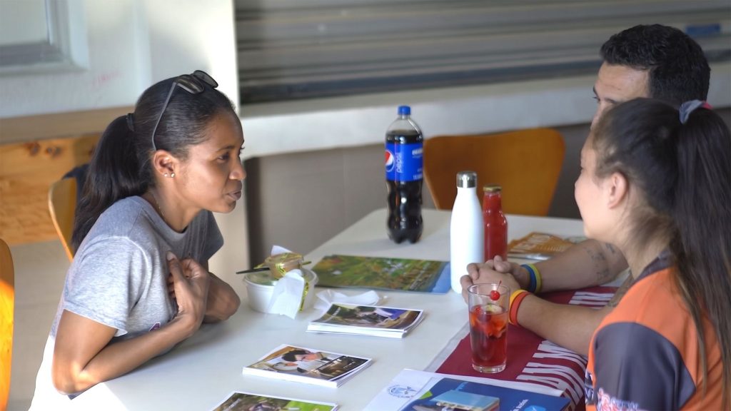 Darlenia Kokoszka of GESP talks with a student and a family member across a table of school brochures