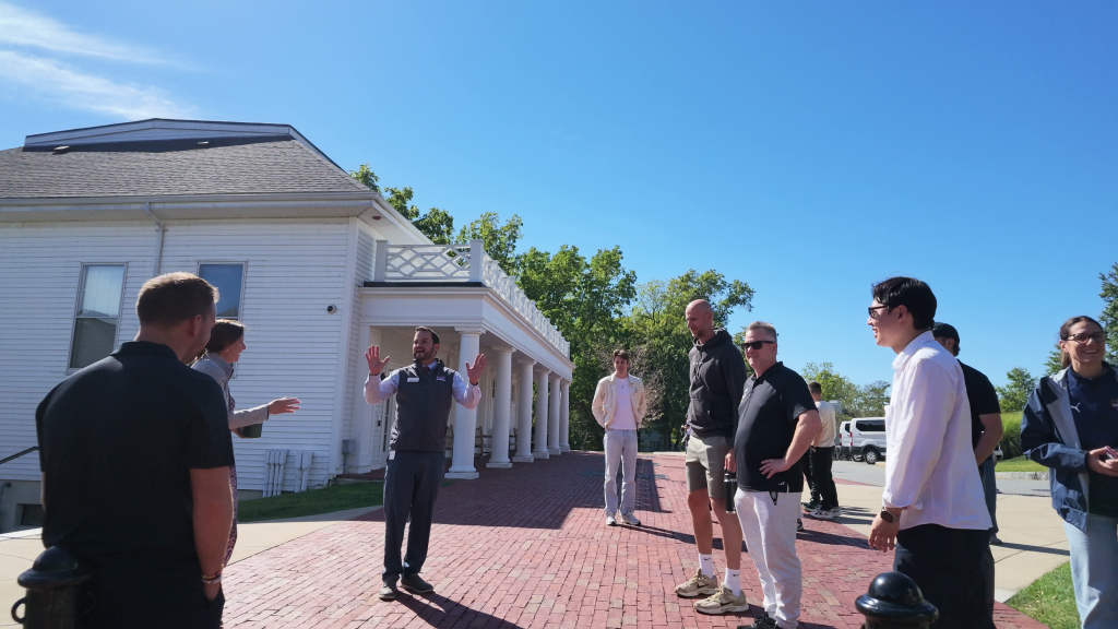 A Fay School host speaks to families on a GESP admissions tour outside a white campus building